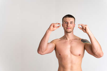 Fish oil is eaten by a man in the hands of vials and a glass bottle oil health healthy, omega...