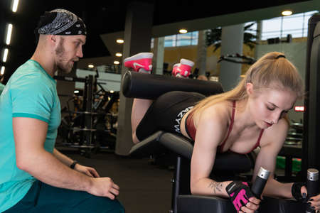 RUSSIA, MOSCOW - FEB 11, 2022: The girl is engaged with trainers in the fitness room on the simulator lying down, the concept of sports lifeのeditorial素材