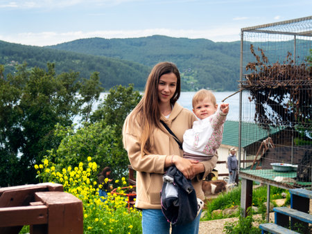 Photo of a young mother with a child against the backdrop of nature, forest and mountains on a sunny summer dayの写真素材