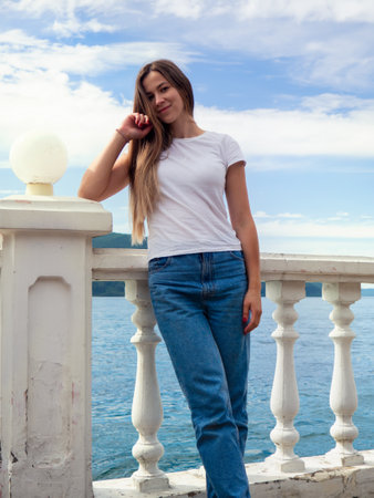 Photo of a girl leaning on the embankment parapet. The photo was taken on a clear summer day.の写真素材