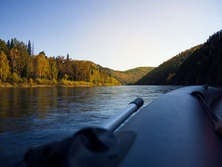 The river of Siberia, a forest bank with hills and a rock is depicted. The image was taken in early autumn, on a sunny dayの写真素材