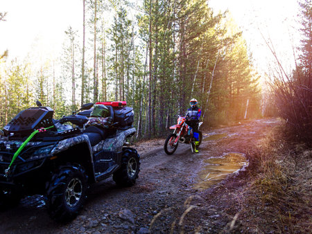 ATV and cross-country enduro motorcycle on a forest road in autumnの写真素材