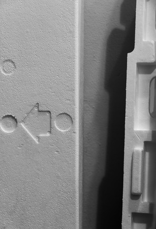 Styrofoam that has an arrow pointing to the left direction with its cover on the right in black and white.の写真素材