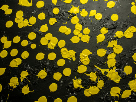 Yellow paint drops on black background. Top view. Flat lay.の写真素材
