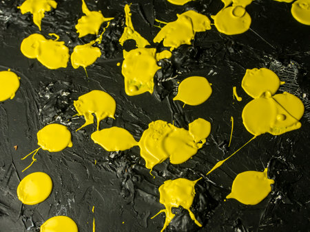 Yellow oil paint splashes on black background. Top view, flat lay.の写真素材