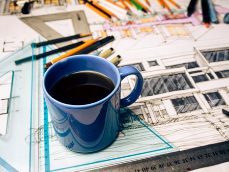 Cup of coffee on the table with architectural drawings and equipment.の写真素材