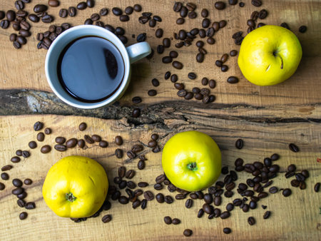 Cup of coffee, apples and coffee beans on a wooden tableの写真素材