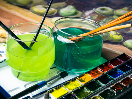 Paint brushes and watercolors on a table in a studioの写真素材