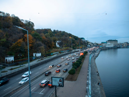 Traffic on the embankment of Kiev. Downtown of Kyiv, Ukraine in autumn. Dnipro river and yellow...