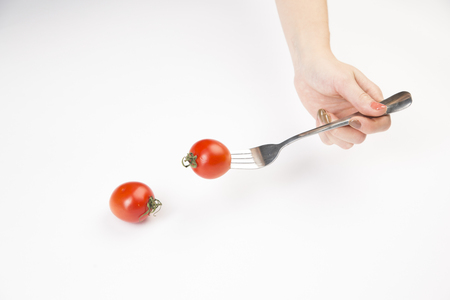 Red tomato gently in your hand on a white backgroundの写真素材