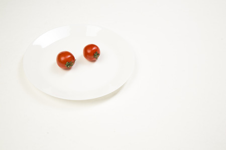 Red tomato gently in your hand on a white backgroundの写真素材