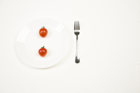Red tomato gently in your hand on a white backgroundの写真素材