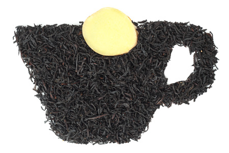 Tea leaves in the form of a cup with a slice of ginger on white の写真素材