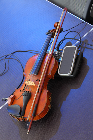 Violin with a pickup  Old violin lying on stage の写真素材