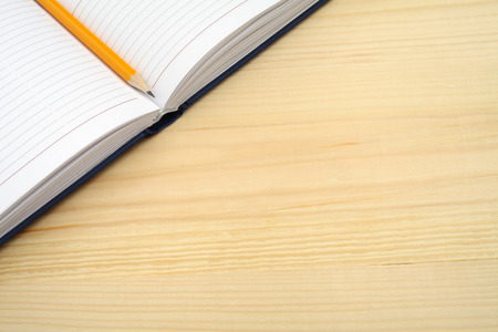 Diary and pencil on wooden tableの写真素材