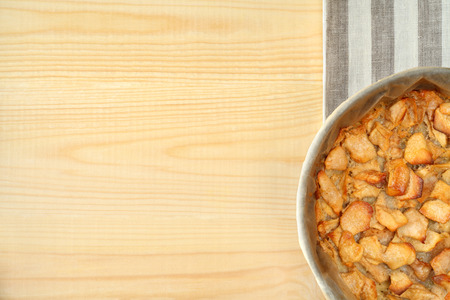 Freshly baked hot apple pie in baking dish on wooden table with free text space.の写真素材