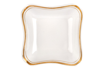 Vintage plate of unusual shape with gold rim isolated. Bowl top view.の写真素材