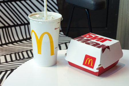 Minsk, Belarus, May 6, 2018: Big Mac Box and soft drink with McDonald's logo on table in McDonald's Restaurantのeditorial素材