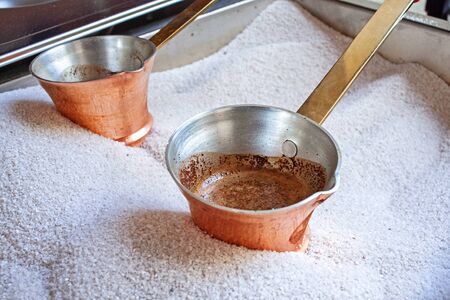 Hot tasty Coffee from copper cezve prepared on hot sand. Cezve to kitchen.の写真素材