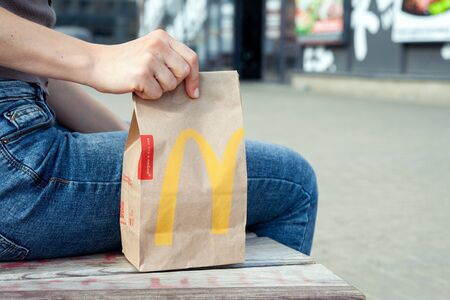 Minsk, Belarus, July 02, 2019: Woman holds takeout packing paper bag with lunch from McDonald's restaurant in her handのeditorial素材