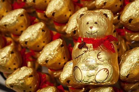 MINSK, BELARUS - December 13, 2019: Chocolate Teddy Bears by Lindt for Sale in a Shop. Background of chocolate bears in gold foil.のeditorial素材