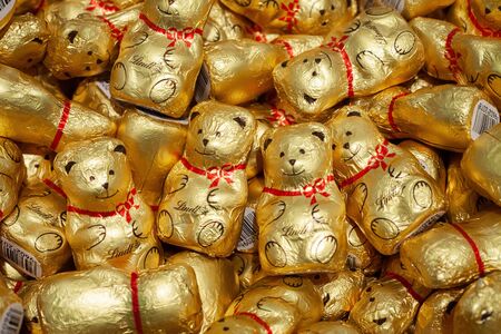 MINSK, BELARUS - December 13, 2019: Chocolate Teddy Bears by Lindt for Sale in a Shop. Background of chocolate bears in gold foil.のeditorial素材