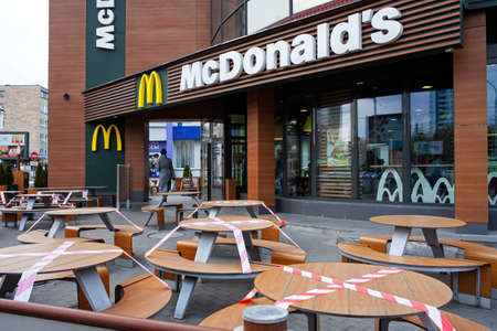 MINSK, BELARUS - April 20, 2020: Signal tape to block, close tables on McDonald's restaurant terrace for social distancing purpose to stop spreading coronavirus covid-19 for public health safetyのeditorial素材