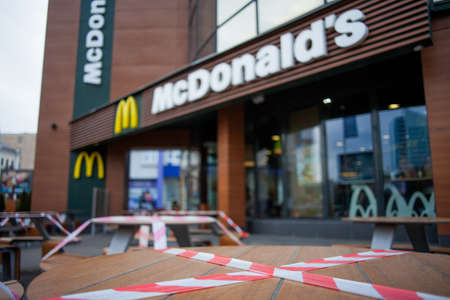MINSK, BELARUS - April 20, 2020: Signal tape to block, close tables on McDonald's restaurant terrace for social distancing purpose to stop spreading coronavirus covid-19 for public health safetyのeditorial素材