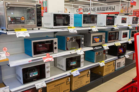 Various brands of oven and microwave on store shelf. Minsk, Belarus - February 7, 2022