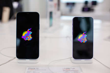 Apple iPhone 12 and Apple iPhone SE with Apple Logo on screen is sold at Apple store. Minsk, Belarus...
