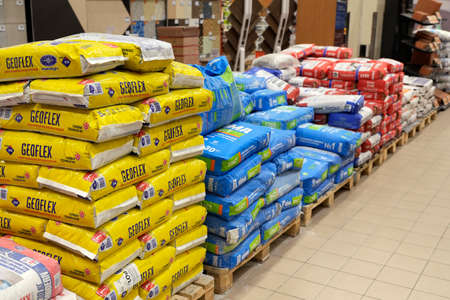 Building materials are sold in a hardware store. Bags of cement, plaster and other goods for construction and repair are stacked on pallets. Minsk, Belarus - march 2022のeditorial素材