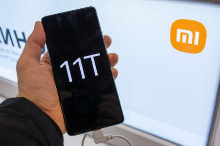 Smartphone Xiaomi in hand. Customer choosing smartphone in mobile phones store. Minsk, Belarus - February, 2022のeditorial素材