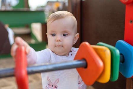 Cute baby Playing on Playground. Toddler playing with colored rings on playgroundの写真素材