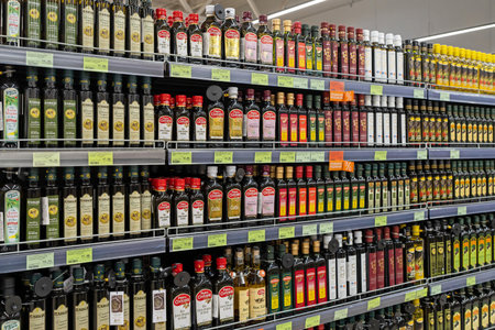 Olive oil of different brands in a grocery store. Large assortment of high quality healthy cooking olive oil. Minsk, Belarus, 2022のeditorial素材
