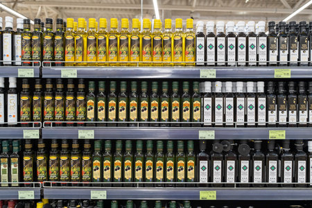 Olive oil of different brands in a grocery store. Large assortment of high quality healthy cooking olive oil. Minsk, Belarus, 2022のeditorial素材