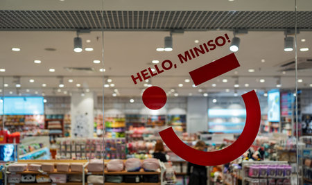 Miniso store interior. The inscription Hello, Miniso! on glass of a shop window. Miniso is a Chinese...