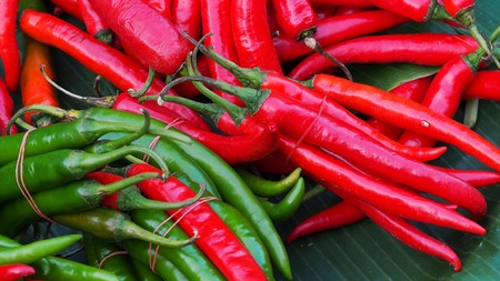 Green and Red chili peppers over on banana leaf