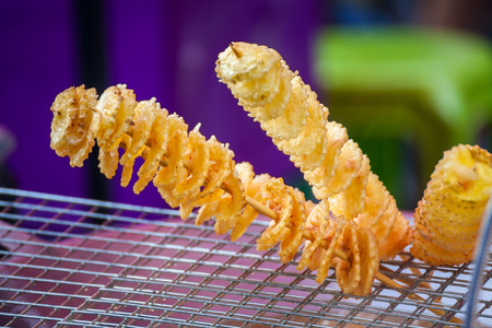 Fried in oil potato chips on wooden sticksの写真素材
