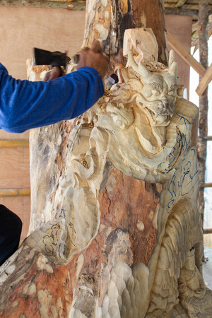 Craftsman carving wood of a dragon.の写真素材