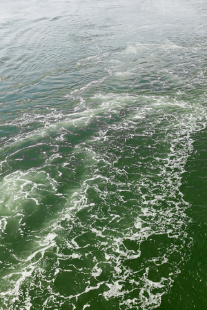 Water steam at sea after speed boatの写真素材