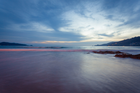 Beautiful  sunset at the rock beach at Patong beach , Phuket island, Thailandの写真素材