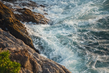 Sea waves crashing against the rocks,Phromthep Cape south of Phuketの写真素材