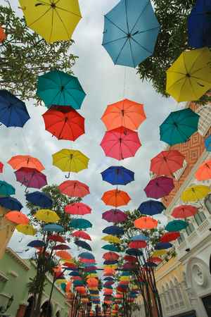 Street decoration with colorful open umbrellas hanging over the street. Hua Hin, Thailandの写真素材