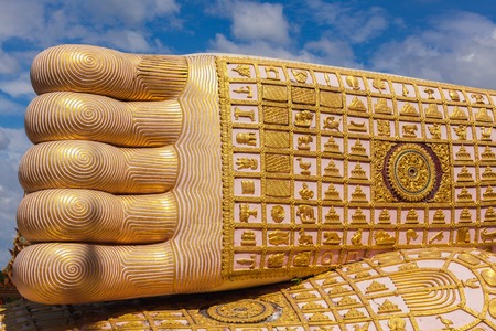 Golden Foot Buddha with a yellow background is the sky.の写真素材