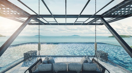 Beautiful balcony Beach lounge,Swing sofa and daybed on the Swimming pool with  the sea at sunlight  - 3d renderingの写真素材