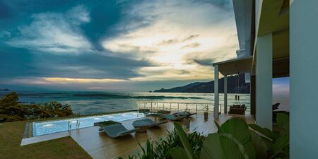 Sea view swimming pool in modern loft design,Luxury ocean Beach house, sunset,3d renderingの写真素材
