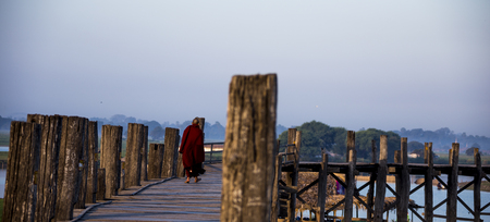 A monk is walking on the U Bein bridgeの写真素材