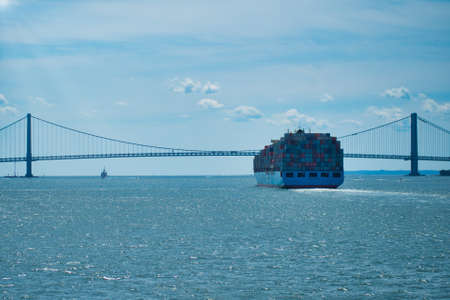 ship with containers near the bridge on a sunny dayの写真素材