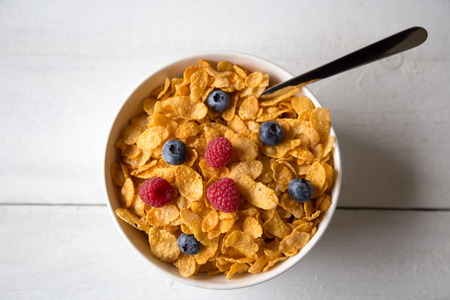 Cornflakes in a bowl with milk and fruits