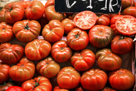 Many beefsteak tomatoes on a market stall.の写真素材